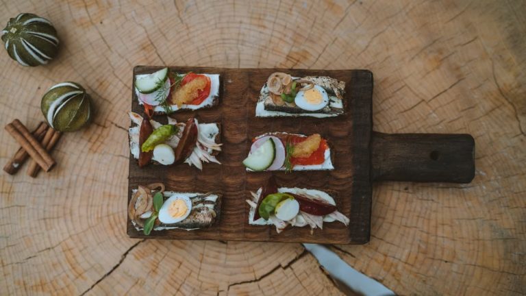 Top view of holiday appetizers on a wooden board with festive elements, creating a cozy rustic feel.